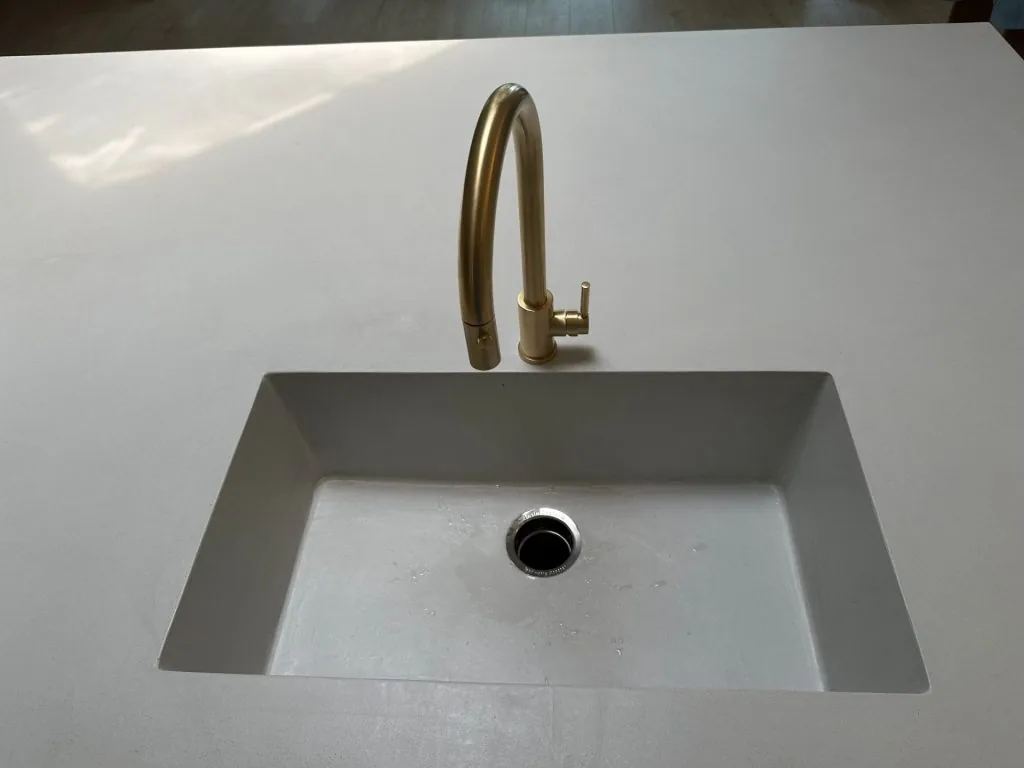 Seamless microcement countertop with integrated sink and brass faucet
