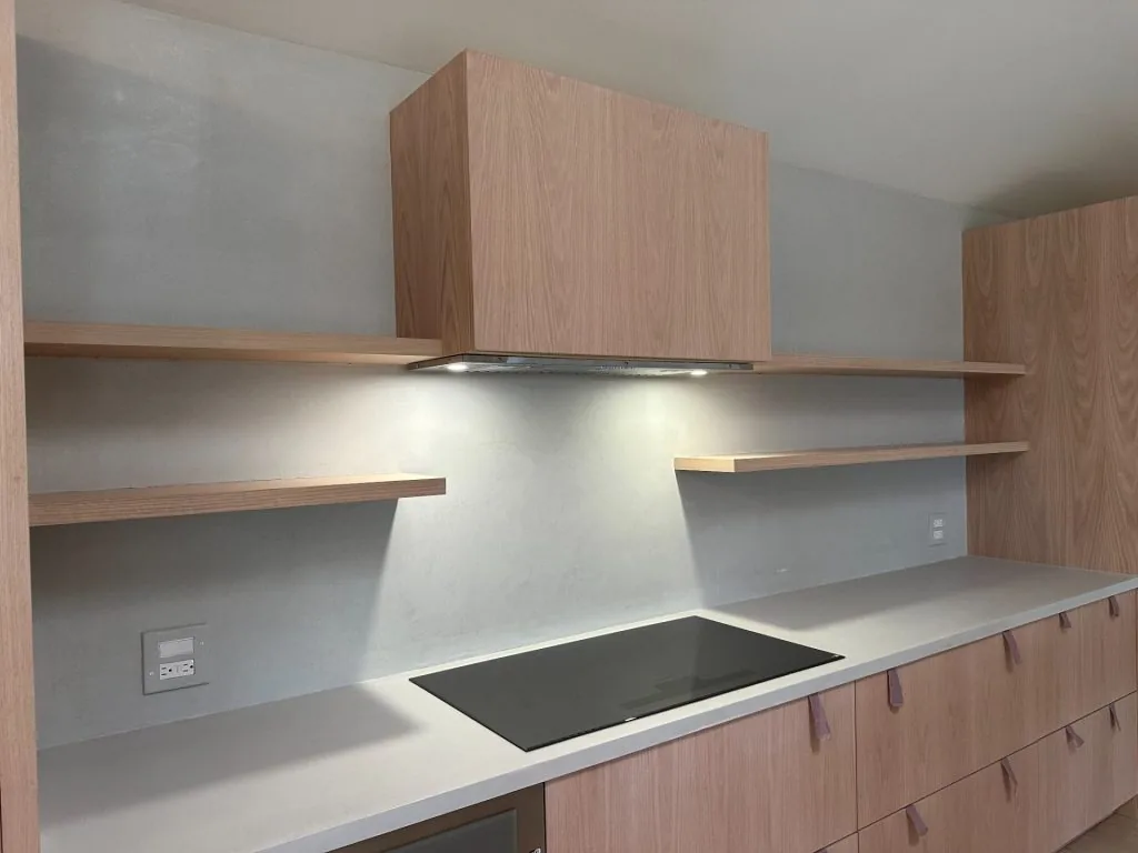 Microcement kitchen backsplash and countertop with floating wood shelves