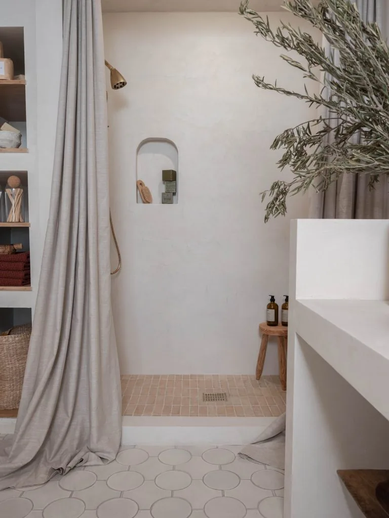 Microcement walk-in shower wall and seamless bathroom finish