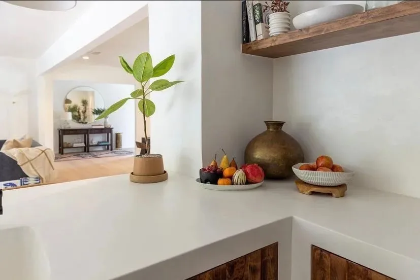 Waterfall-edge microcement countertop over custom wood cabinetry